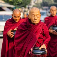 Monks in red robes on their morning alms round