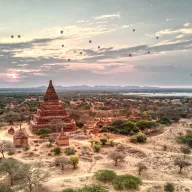 Temples of Bagan with balloons in the sky at sunrise, from above
