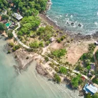 Coastline with bungalows and palm trees, from above