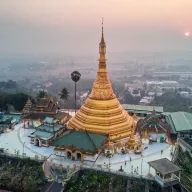 Golden pagoda on a hill at sunrise, from above