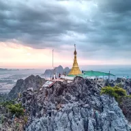 Pagoda on a karst rock under a cloudy sky