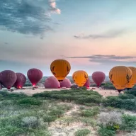 Hot-air balloons being inflated at dawn, from above