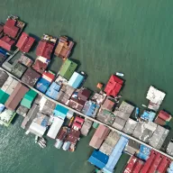 Colourful roofs of a fishing village on stilts in the sea, from above