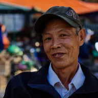 Smiling elderly man with a cap at the market
