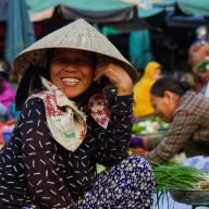 Laughing market woman with a straw hat