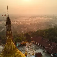 Golden pagoda spire above a hazy morning landscape, from above