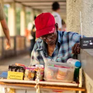 Man with a red cap and a radio at a small stall