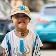 Boy with a cap sticking out his tongue