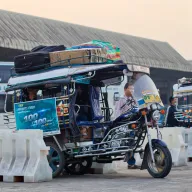 Tuk-tuk with luggage on the roof at a bus station