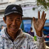 Laughing man with a cap waving