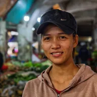 Young woman with a black cap at the market